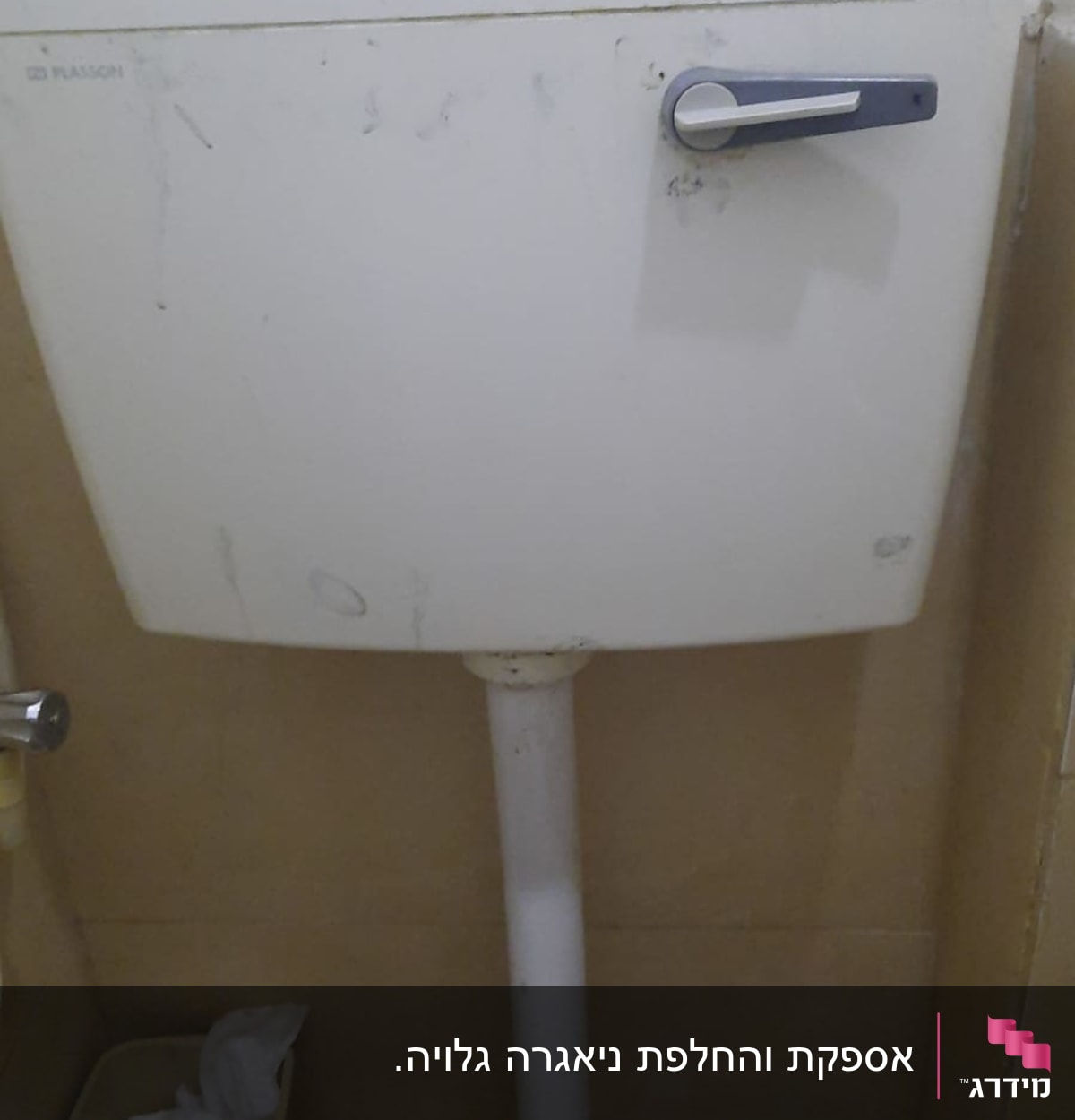 ניאגרה לבנה עם ידית מתכת בחדר אמבטיה